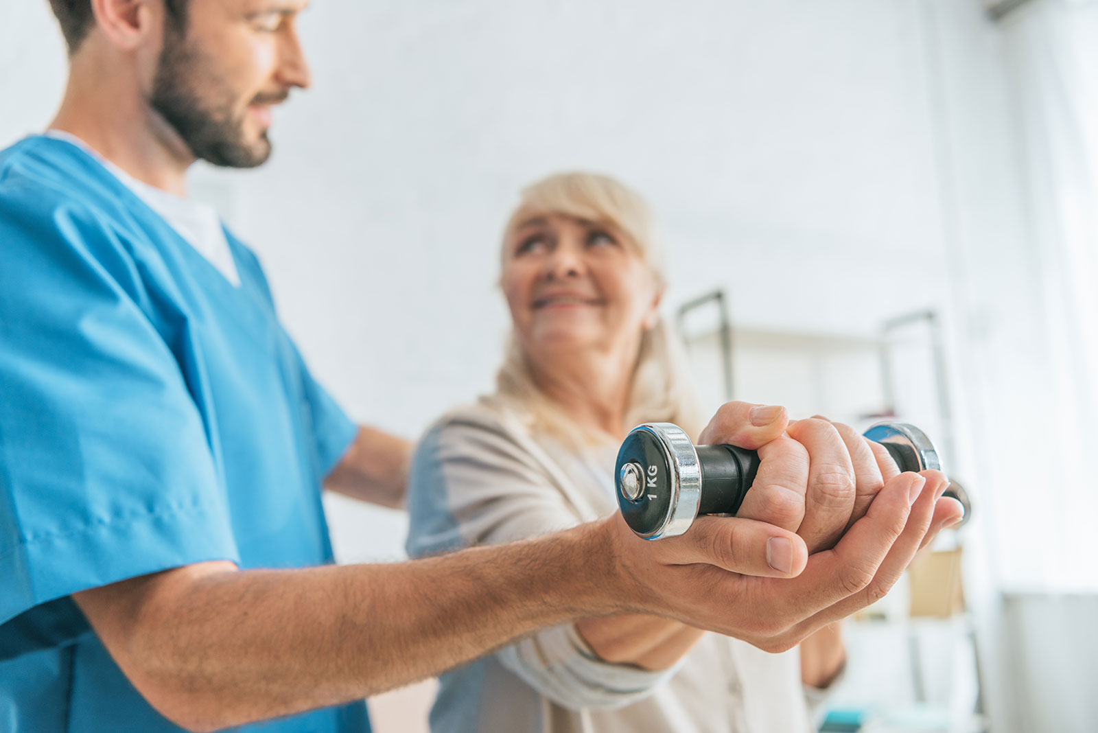 Physical therapy session with dumbbells and smiling individuals.