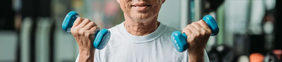 Older man holding blue dumbells