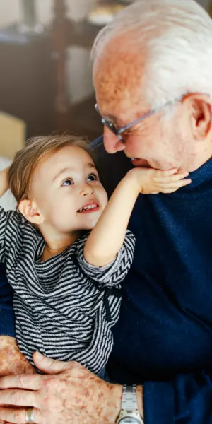 Child and elderly man sharing a happy, tender moment.