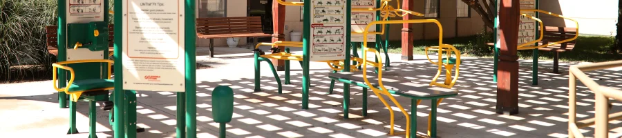 Outdoor gym equipment with instructional signs.